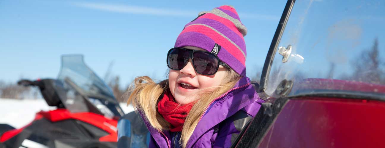 Barn som sitter på en skoter.